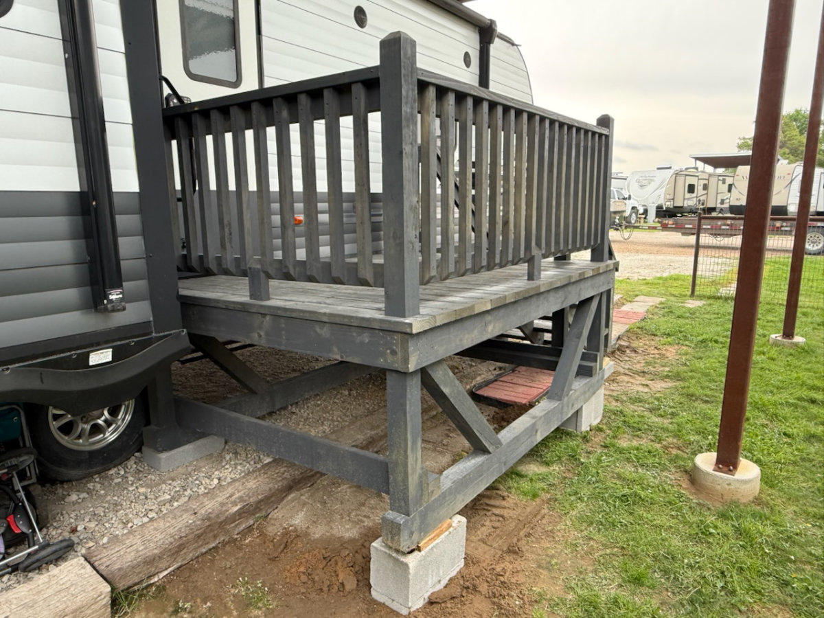 Dark-stained portable deck with railing