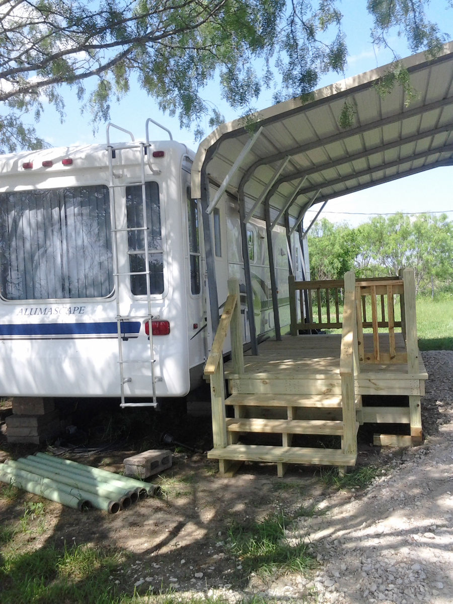 Light wood portable deck with steps beside an RV
