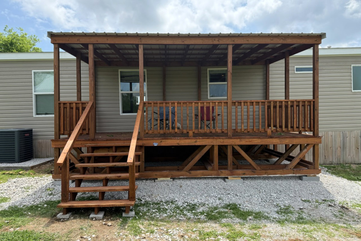 Brown-stained covered portable deck with metal roof